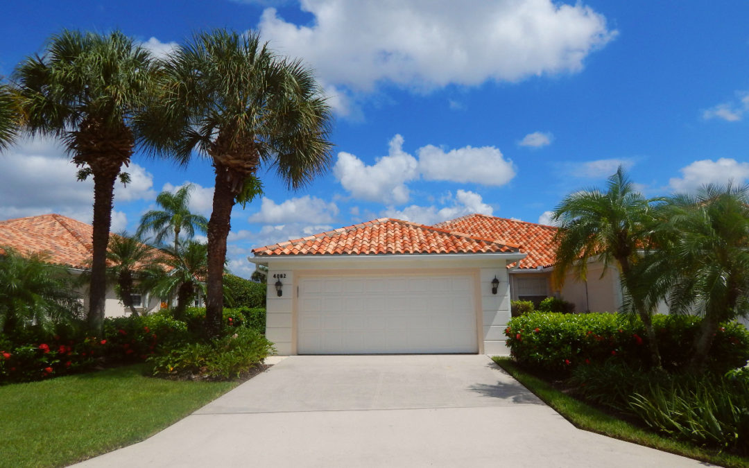 Picture describes a house in Village Walk with blue sky and palms