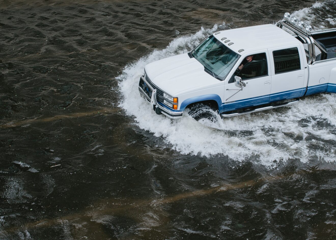 A truck drives through flooded streets.