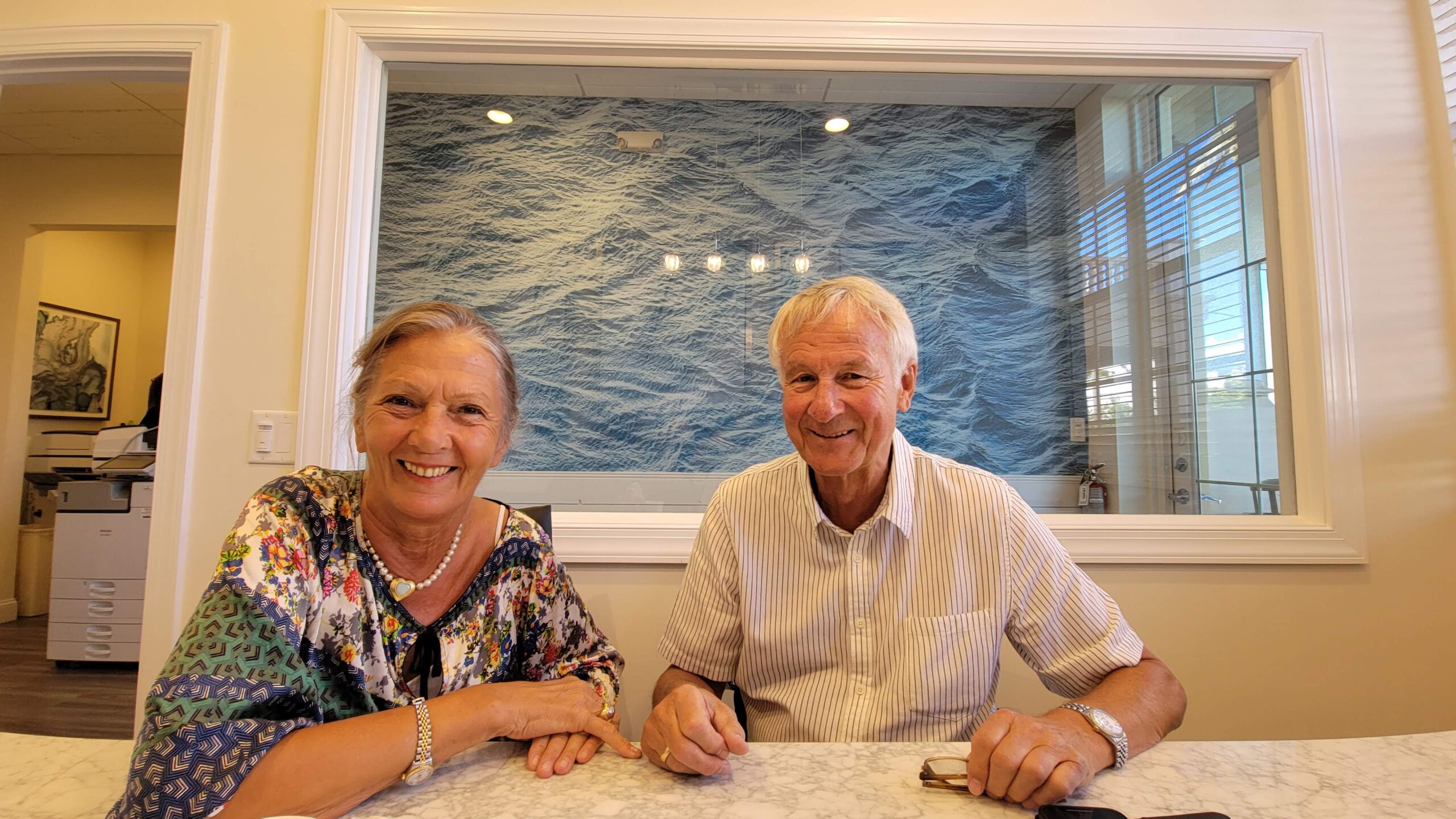 Elderly couple sitting on the table happy and satisfied after closing of condo