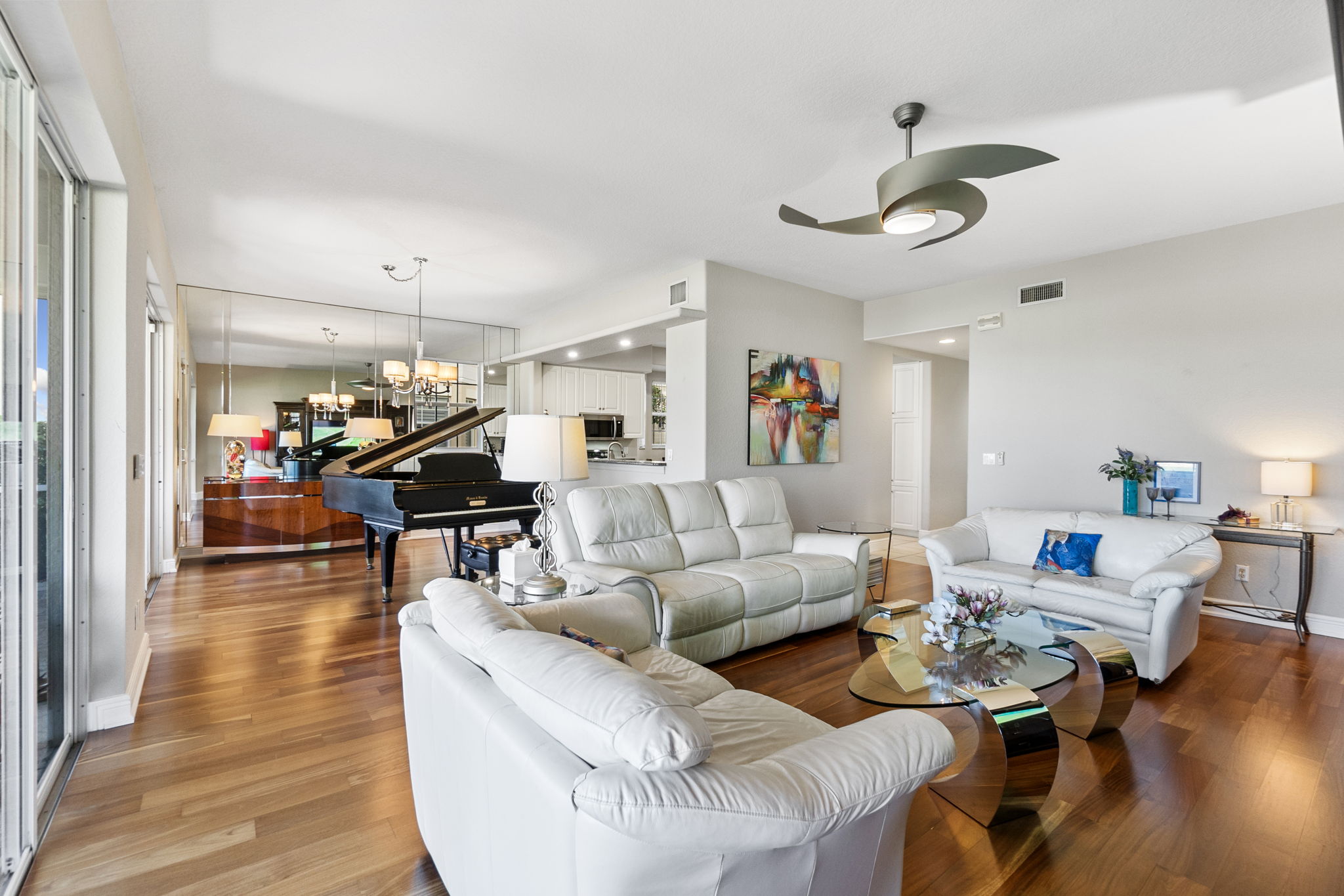 An elegant living room with a ceiling fan and a piano, offering a serene space for leisure and musical enjoyment.