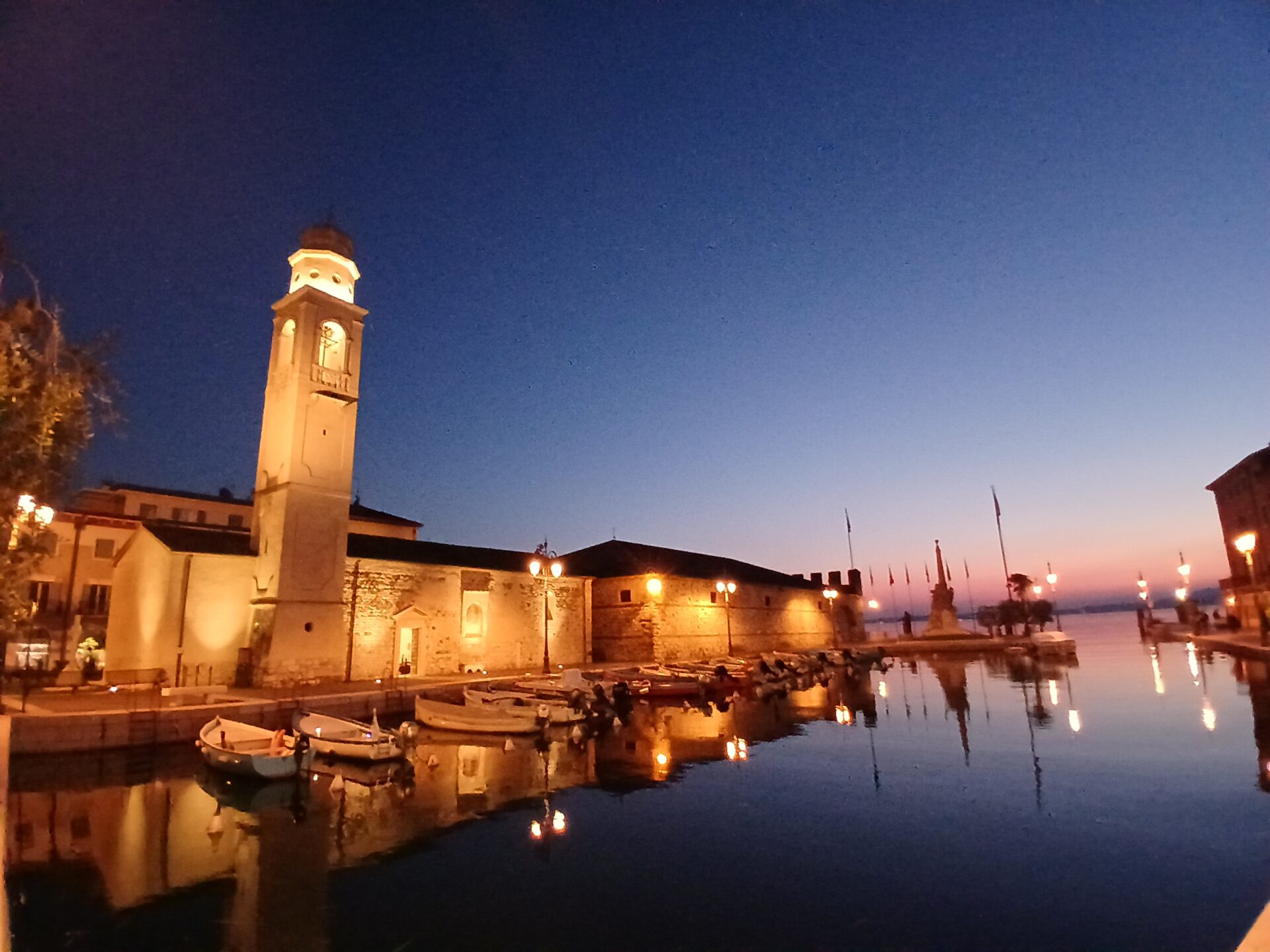 Aerial view of a mill surrounded by lush gardens and trees.