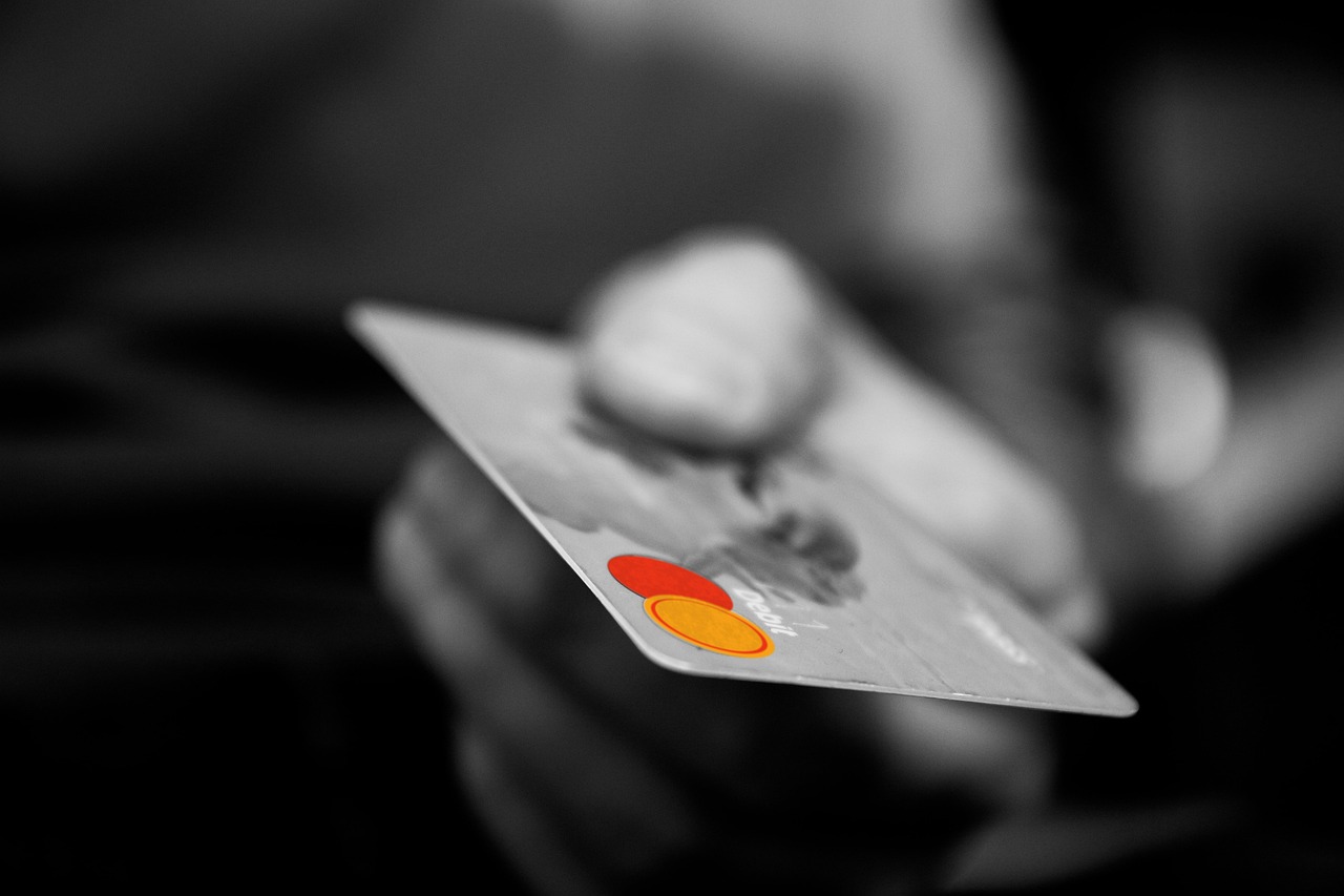 Hand holding a credit-debit card in Naples, FL representing taxable sales and consumer spending