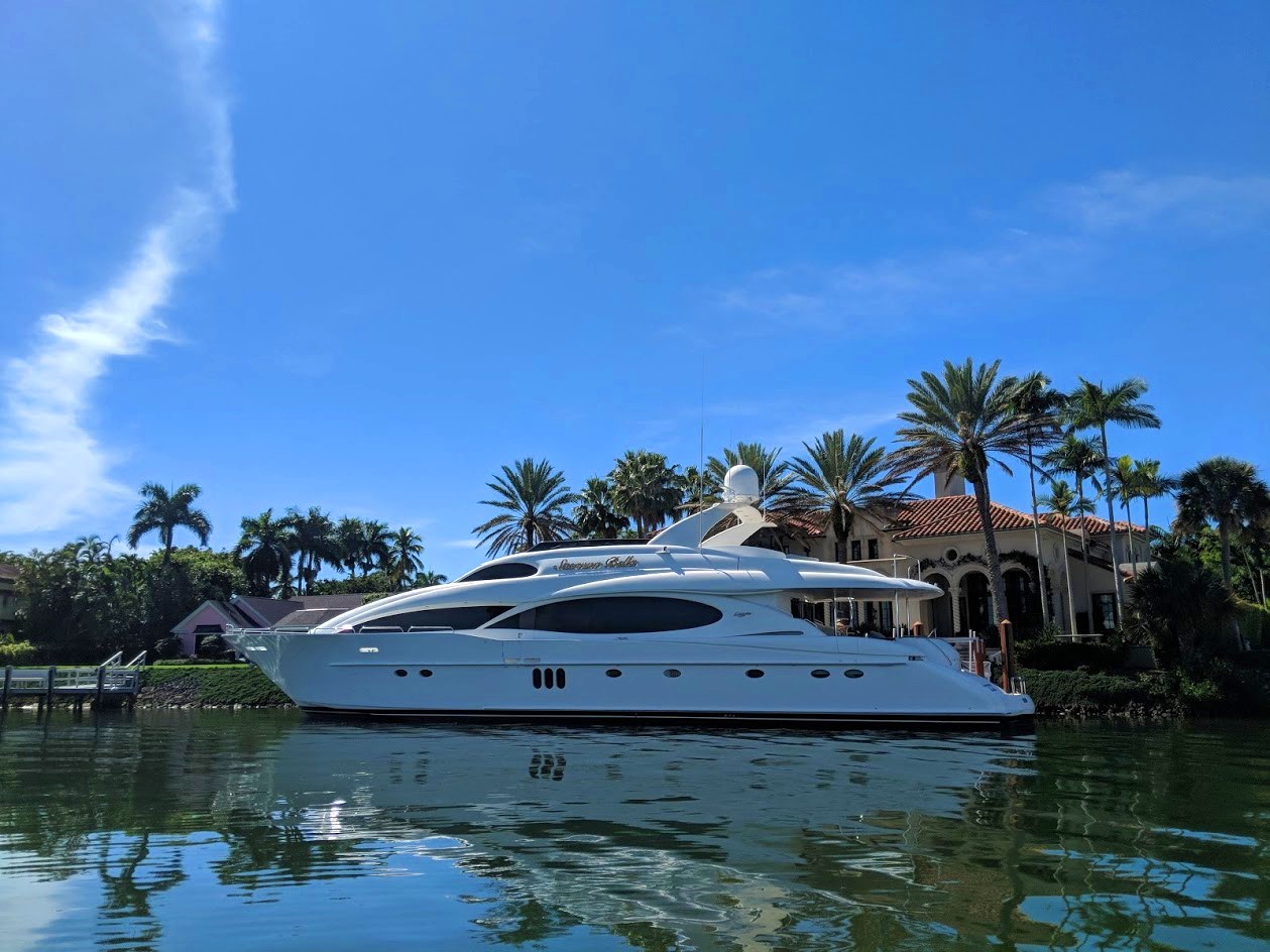 Luxury yacht docked in front of a waterfront estate in Port Royal Naples, Florida