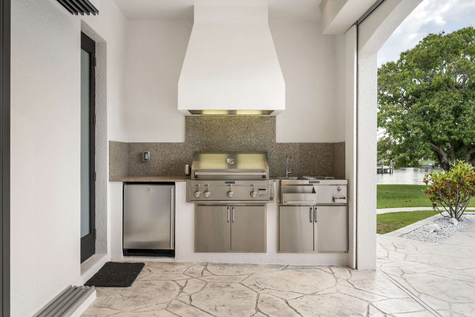 Überdachte Outdoor-Küche mit Grill und Blick in den Garten bei 4944 Normandy Court Cape Coral