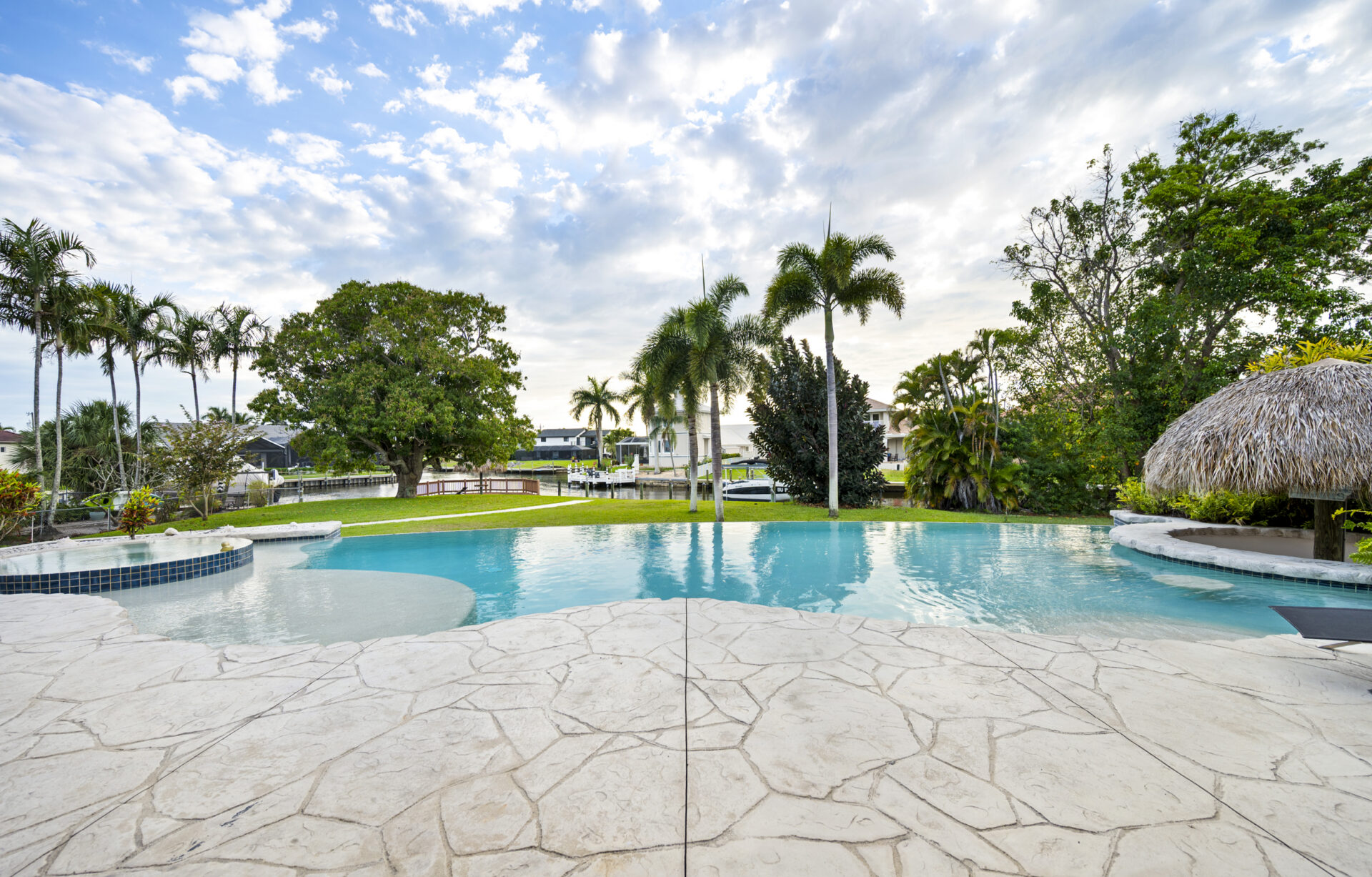 Großzügiger Pool mit tropischem Garten und Blick auf den Wasserkanal – 4944 Normandy Court, Cape Coral, Florida